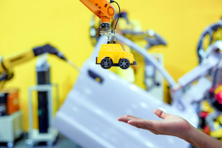 toy yellow car and human hand