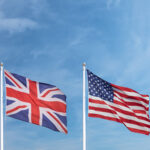Waving English and American flag in front of a blue sky